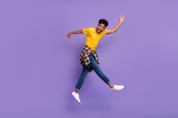 Full length body size view of attractive cheery funky guy jumping having fun running fooling isolated over violet purple color background