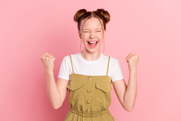 Portrait of attractive cheerful pre-teen girl celebrating great success breakthrough isolated over...