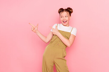 Portrait of attractive trendy cheerful girl demonstrating ad copy space new isolated over pink pastel color background