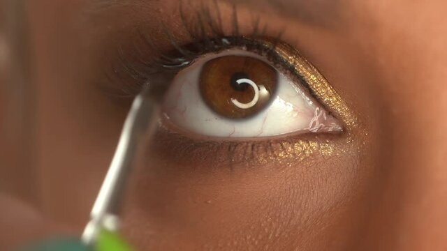 cropped view of african american woman applying cosmetic product on eyelashes