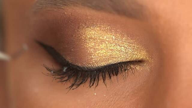 cropped view of african american woman apply black false eyelashes