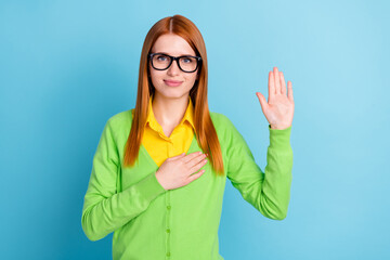 Photo of optimistic young ginger hairdo lady pray wear spectacles green sweater isolated on blue...