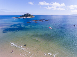 A kite surfer in the sea with St MIchaels Mount (Cornwall, England) behind