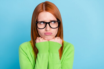 Photo of young sad lady look empty space wear spectacles green sweater isolated on blue color...