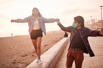 Pareja de jóvenes enamorados caminan por la playa durante un bello atardecer.. Jóvenes felices...