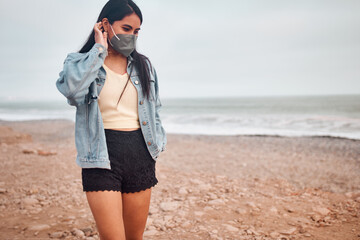 Mujer Joven latina posa caminando en la arena durante un bello atardecer.. Joven feliz  con...