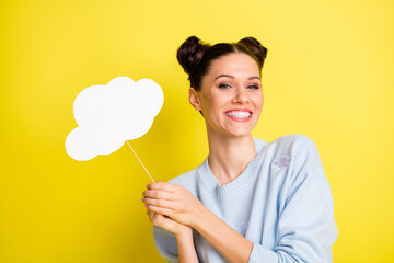 Photo of young attractive beautiful smiling good mood girl holding paper cloud isolated on yellow...