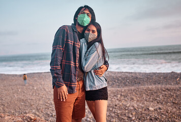Pareja de jóvenes enamorados caminan por la playa durante un bello atardecer.. Jóvenes felices...