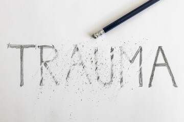 Erasing trauma. Trauma written on white paper with a pencil, partially erased with an eraser....