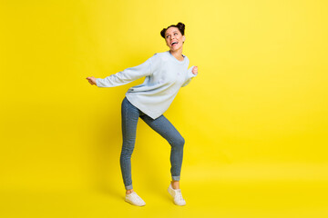 Fototapeta na wymiar Photo of dream lady dance open mouth look empty space wear blue sweater jeans sneakers isolated yellow background