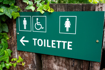 Green direction sign toilette, men ,women and disabled.