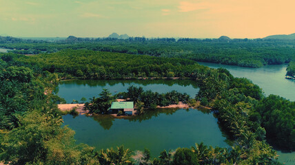 AERIAL. Top film style view of traditional thai boat and river with mountain on the backrgound.