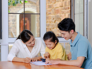 A Happy family of three using calculator