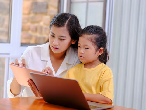 Young Happy mother and daughter use tablet