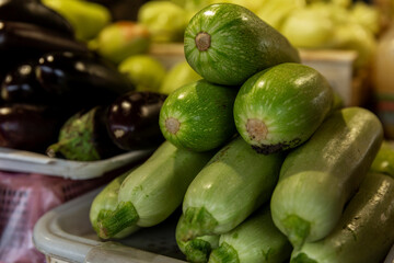 Lots of fresh zucchini on the market counter. Healthy food and vitamins. Close-up.
