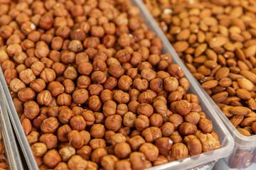 Nuts in boxes on the market counter. Healthy food, vitamins and veganism. Top view. Hazelnuts and almonds.