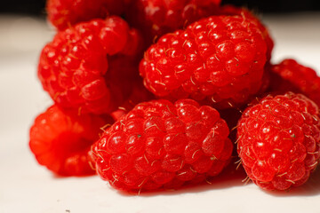 Beautiful raspberries in triangle shape lies isolated on a white background. Cut out, close up. Background and picture for postcard