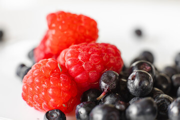 Two different kinds on berries on white plate