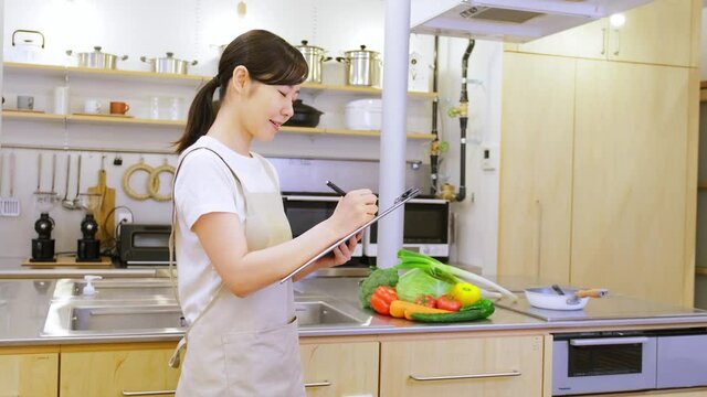 バインダーをもってご飯の献立に悩む家事代行の女性作業員