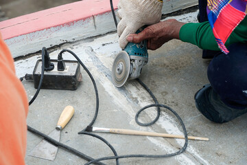 Worker grind hard floor. Worker with high shear grinder cut and mill cement or asphalt or concrete...