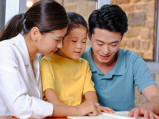 Fototapeta premium A Happy family of three reading together