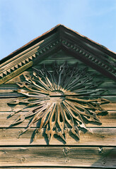 Part of pediment with decor. Old Russian wooden house in an urban environment.