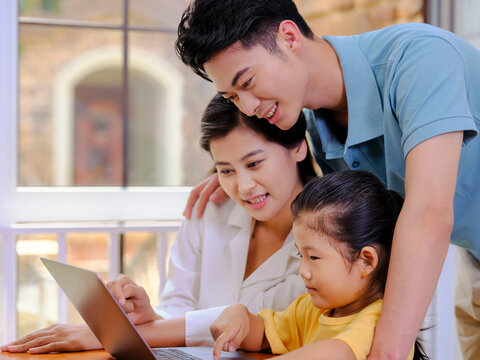 A Happy family of three using laptop