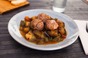 baked meatballs with stewed eggplant, zucchini, green peppers and tomatoes with haze in bowl