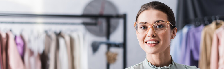 Happy seamstress smiling at camera in atelier, banner