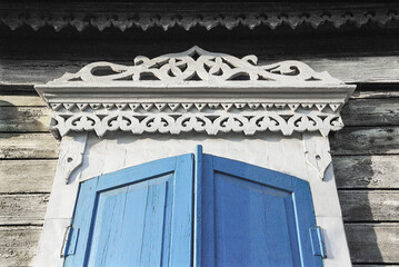 Part of the window with elements of decoration of an old Russian wooden house from the times of the Russian Empire.