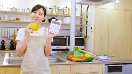 電卓を持ちやりくりに悩む家事代行の女性作業員