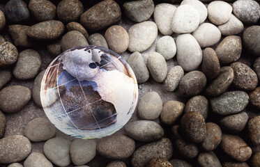 Glass globe world on the small round rock stone background, Enviromental day background concept