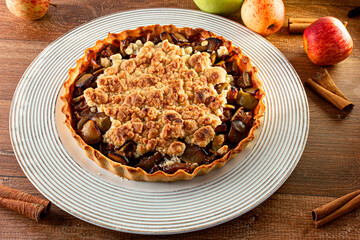Apple Pie with apples and cinnamon on a wooden table