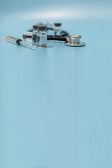 coronavirus vaccine bottle, stethoscope and medical equipment witch copy space on blue background, virus prevention, vaccination, medical technology, research laboratory, covid-19 vaccine concept