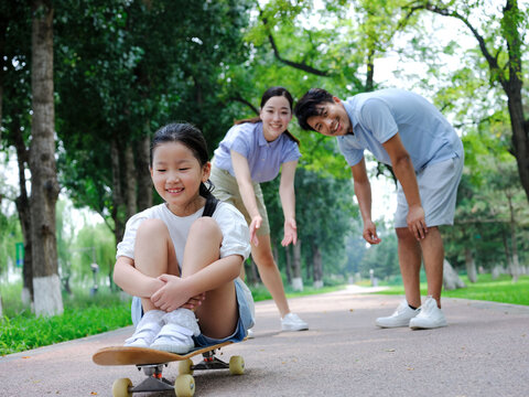 A Happy family of three skateboarding