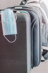 close up of black suitcases with protective mask.Travel concept