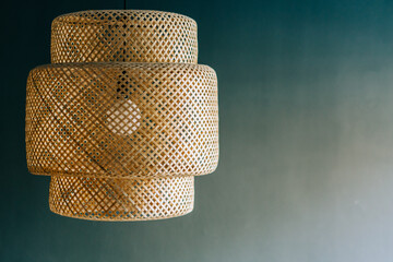 Wicker lamp hanging from the ceiling gray background