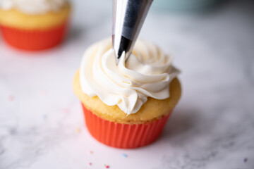 pipping flosting on colorful cupcake