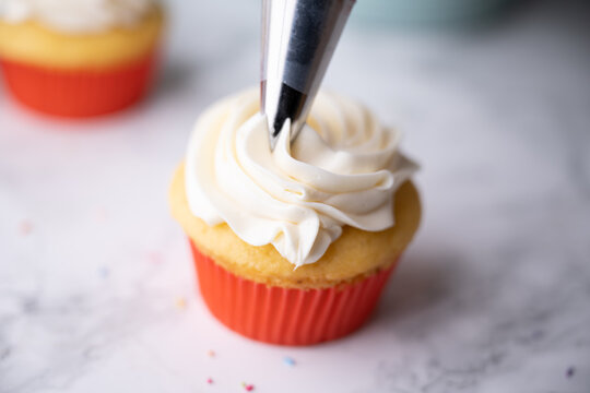 pipping flosting on colorful cupcake