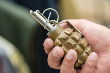 Combat grenade in the hand of a military training instructor. Demonstration of small explosives....