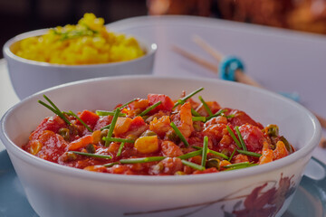 Prawn curry and rice garnished with chive.