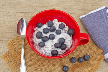 bol de muesli, yaourt et myrtilles sur une table