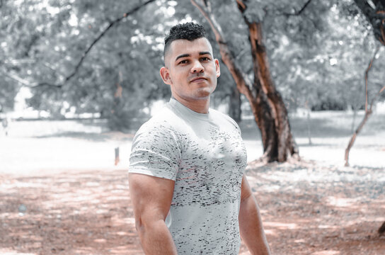 athletic man of Latin origin after training with a tough attitude with a yellow sweater or walks with a hood and a bad man's face, Venezuelan model in sports in the park