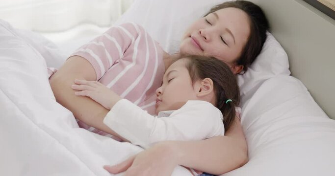 mother and daughter are sleeping on the bed 1