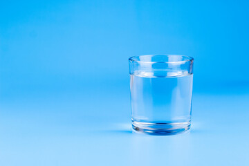 Fresh water in glass on aqua blue background. Part of set.