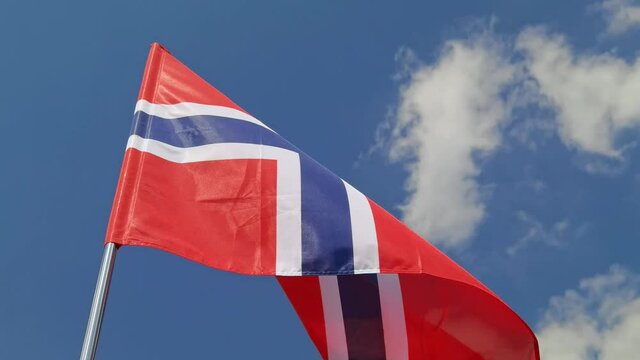 Norway. National country flag on blue sky background. Flying fabric symbol. Tourism or travel summer day. international patriotic emblem. Nobody. Horizontal video