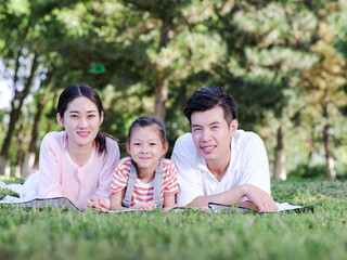 Fototapeta premium Happy family of three on the park grass
