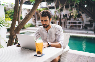 Focused young man using laptop for searching information on internet
