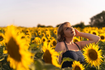 Chica joven guapa sonriendo y posando en un campo de girasoles