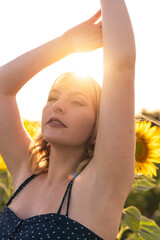 Chica joven guapa sonriendo y posando en un campo de girasoles